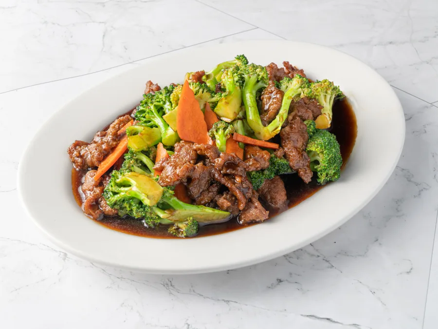 Beef broccoli with carrots in glossy brown sauce on an oval plate