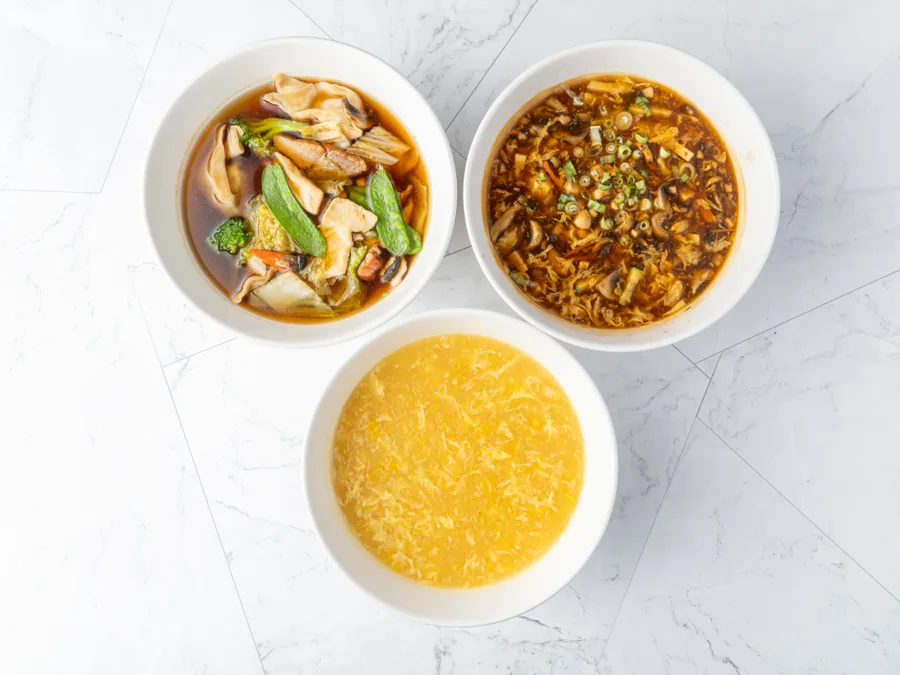 Three bowls of soup viewed from above: vegetable tofu, wonton and egg flower