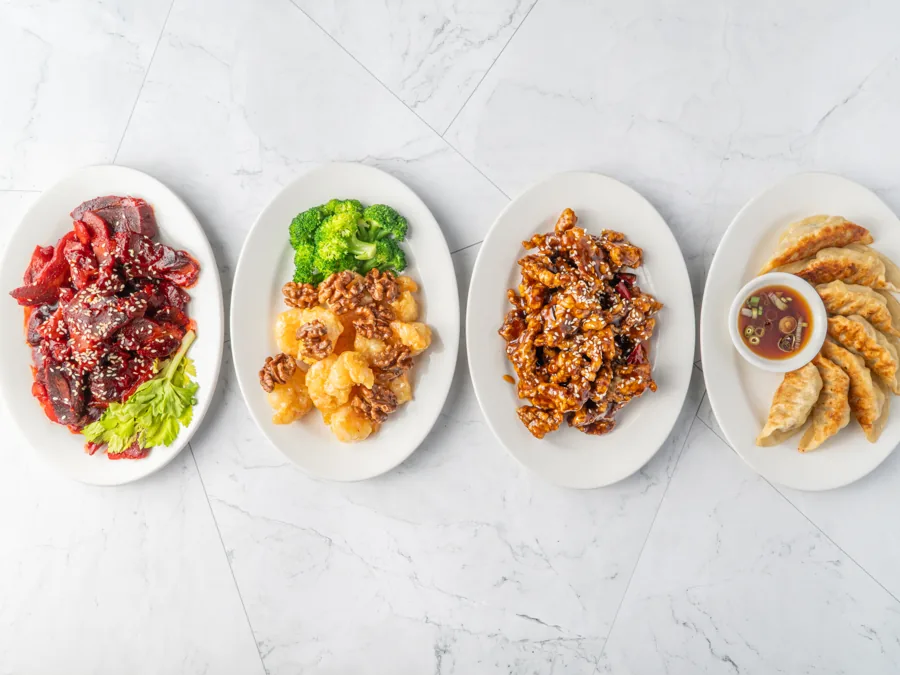 Four plates in a row: beef, walnut shrimp, kung pao chicken and pot stickers