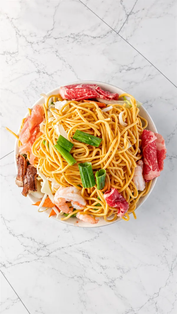A Mongolian BBQ bowl before grilling: noodles with sliced beef, shrimp, mushrooms and cabbage