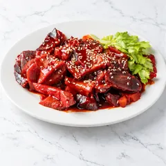 Sliced barbecue pork (char siu) with sesame seeds and a sprig of celery leaf