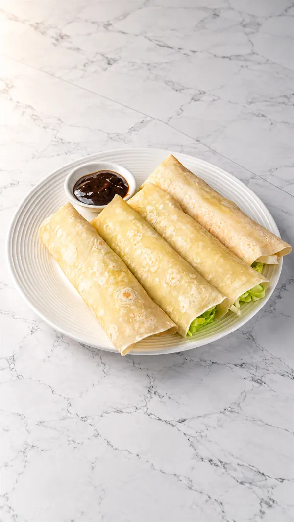 Four rolled moo shu pancakes with hoisin sauce