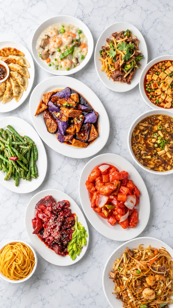 Overhead spread of dishes: pot stickers, green beans, walnut shrimp, orange chicken, mapo tofu, noodles and soups